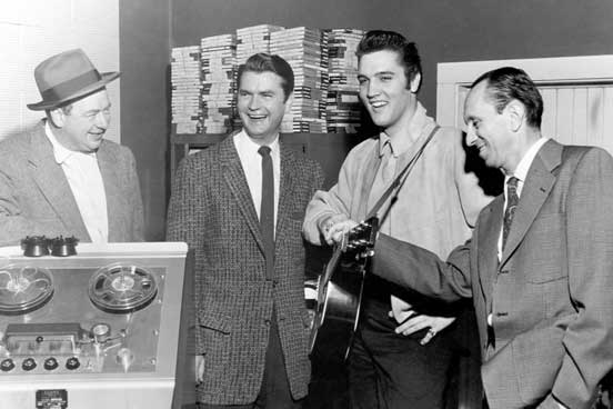 Elvis Presley poses with record producer Sam Phillips, Leo Soroka and Robert Johnson at Sun Recording Studios in Memphis, Tennessee on December 4th, 1956